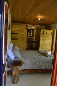 um quarto com uma cama num chalé de madeira em Habitación Las Bromelias, Pijao, Finca Flora del Rio em Pijao