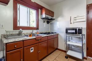 a small kitchen with a sink and a microwave at 1 Bus Stop To NYC-Hot Tub-EWR Airport-Free Parking in Hillside
