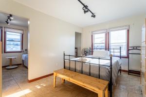 a bedroom with a bed and a wooden bench at 1 Bus Stop To NYC-Hot Tub-EWR Airport-Free Parking in Hillside