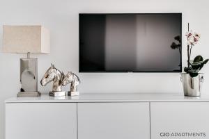 a shelf with a tv and a horse statue on it at GIO Apartments, Luxury, Old Town Cracow in Krakow