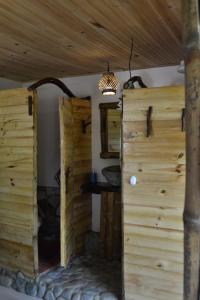 uma porta aberta num quarto com uma parede de madeira em Habitación Las Bromelias, Pijao, Finca Flora del Rio em Pijao