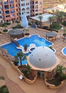 een resort met een zwembad en een gebouw bij Playa Honda vistas al mar, 1a Línea playa, PARKING, WIFI in Playa Honda