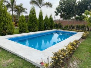 una piscina en un patio con árboles en Finca Las Palmeras - Rcreat, en Lima