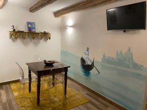 Habitación con TV, mesa y un barco en la pared. en CA' DE' KOCAI, en Venecia