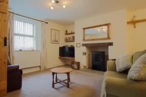 a living room with a couch and a fireplace at Tannery Mews in Chudleigh
