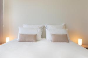 a white bed with white pillows on it at Infinity pool & Amazing Sunset Ocean View in Funchal +28 photos