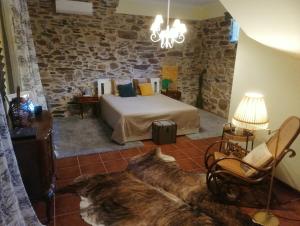 a bedroom with a bed and a chair in a room at Casa do Adro-Passadiços do Paiva Arouca in Arouca