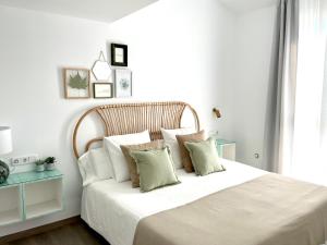 格拉纳达Apartamentos con encanto en el centro de Granada的卧室里有一张大床，床单和枕头都是白色的