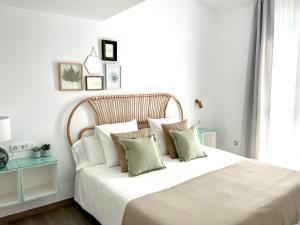 a bedroom with a large bed with white sheets and pillows at Apartamentos con encanto en el centro de Granada in Granada