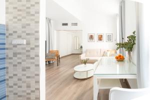 格拉纳达Apartamentos con encanto en el centro de Granada的客厅里有一张白色的沙发和一张桌子