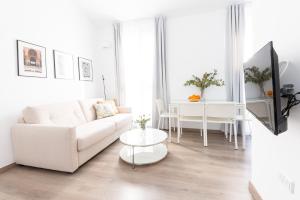格拉纳达Apartamentos con encanto en el centro de Granada的白色的客厅配有白色的沙发和桌子