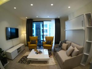 a living room with a couch and two chairs at Luxury Apartment in DAMAC Towers in Amman