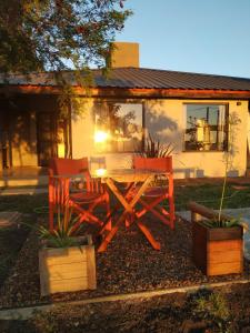 a picnic table and two chairs in front of a house at RIO ARRIBA in Colón