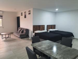 Habitación con 2 camas, mesa y sofá en Life en Puerto Peñasco