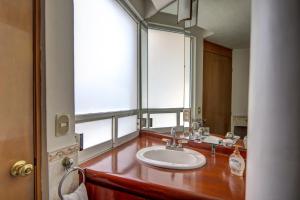 a bathroom with a sink and a large mirror at Grupo Kings Suites - Bosques de Duraznos 78 in Mexico City +35 photos