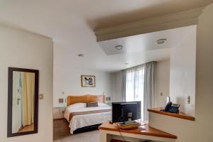 a bedroom with a bed and a mirror at Grupo Kings Suites - Bosques de Duraznos 78 in Mexico City
