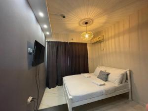 sypialnia z białym łóżkiem z lampką w obiekcie דירות רוטשילד w mieście Petach Tikwa