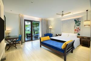 a bedroom with a bed and a desk and a chair at Radisson Resort Pondicherry Bay in Puducherry