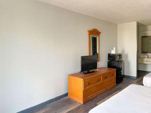 a hotel room with a television on a dresser at Motel 6 Marianna, FL in Marianna