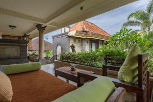 una casa y un patio al aire libre con muebles en Ubud Aura Retreat en Ubud