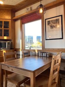 un comedor con una gran mesa de madera y una ventana en Stork Nest Inn, en Smithers
