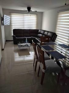 a living room with a black couch and a table at Un pedacito de arena en Cancún in Cancún