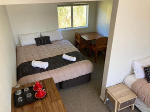 um pequeno quarto com uma cama e um sofá em Woodstock Hotel em Hokitika