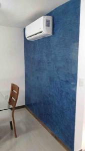 a room with a blue wall with a heater and a chair at Un pedacito de arena en Cancún in Cancún