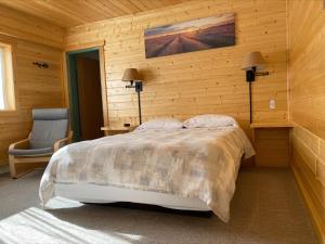 1 dormitorio con 1 cama y 1 silla en una habitación en Stork Nest Inn, en Smithers