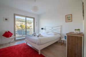 a bedroom with a bed and a large window at Apartment In A Residence With Swimming Pool Wifi in Cannes
