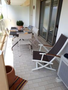Habitación con sillas y mesa en el balcón. en Apartment In A Residence With Swimming Pool Wifi en Cannes