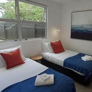 a room with two beds and a window at Harbourside 29B ~ Boat Parking in Coromandel Town