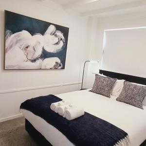 a bedroom with a bed and a painting on the wall at Harbourside 29B ~ Boat Parking in Coromandel Town