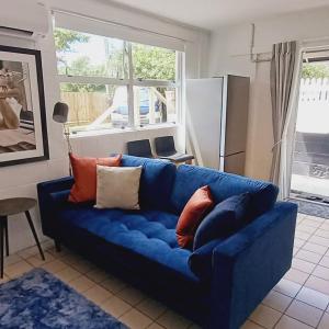 a blue couch with pillows on it in a living room at Harbourside 29B ~ Boat Parking in Coromandel Town +13 photos