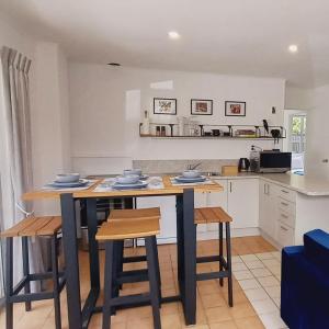 a kitchen with a table and some chairs and a counter at Harbourside 29B ~ Boat Parking in Coromandel Town
