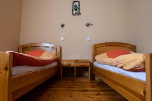 a room with two beds and a table with a night stand at Apartments Peggy in Jahorina