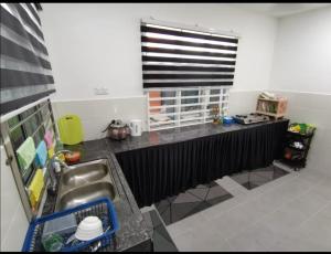 a small kitchen with a sink and a window at Nawra Homestay Besut - Free Wifi in Kampung Raja +10 photos
