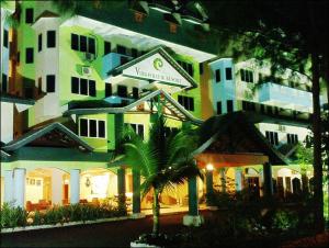 a large building with a palm tree in front of it at Virgo Batik Resort in Lumut