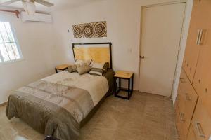 a bedroom with a large bed and two tables at Un pedacito de cielo en Cancun in Cancún