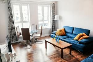 a living room with a blue couch and a table at Harbour Square House in Dublin