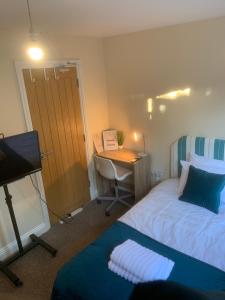 a bedroom with a bed and a desk with a computer at Cosy Room With Private Entrance & Ensuite in Reading