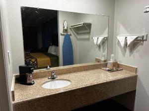 a bathroom counter with a sink and a mirror at Economy Inn Ashdown in Ashdown