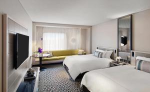 a hotel room with two beds and a couch at The Star Grand Hotel and Residences Sydney in Sydney