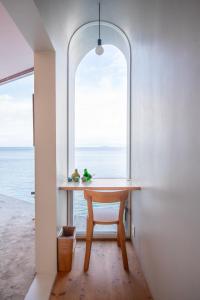 a table and a chair in a room with a window at 佐島 - Nowhere but Sajima - ペット可 in Yokosuka