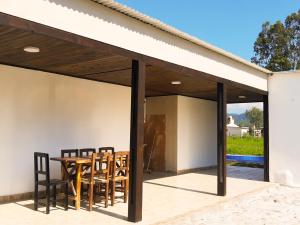eine Glaserweiterung eines Hauses mit einem Tisch und Stühlen in der Unterkunft Ocultar de los Andes in La Silleta