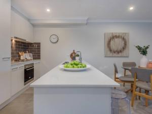 a kitchen with a bowl of fruit on a counter at Merchant's Court, Quiet and Central 3 bedroom townhouse in Wangaratta
