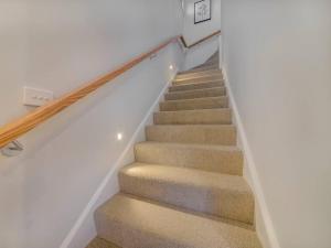 una escalera en una casa con una pared blanca en Merchant's Court, Quiet and Central 3 bedroom townhouse, en Wangaratta