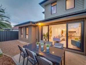 a patio with a table and chairs in front of a house at Merchant's Court, Quiet and Central 3 bedroom townhouse in Wangaratta