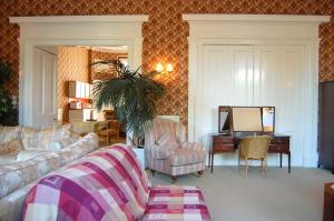 een woonkamer met een bank en een bureau bij Regent Terrace, Central and Charming, Quiet in Edinburgh