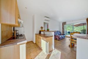 a kitchen and living room with a couch and a table at Appartement d'une chambre avec jardin amenage et wifi a Sartene in Sartène